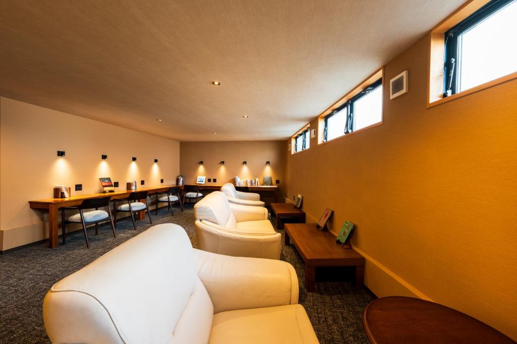 - une salle d'attente avec des canapés blancs, des tables et des fenêtres dans l'établissement Kannawaen, à Beppu 220 autres photos