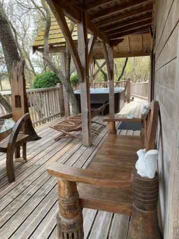 une terrasse en bois avec deux chaises et un banc dans l'établissement Cabane d'Amour, à Béziers