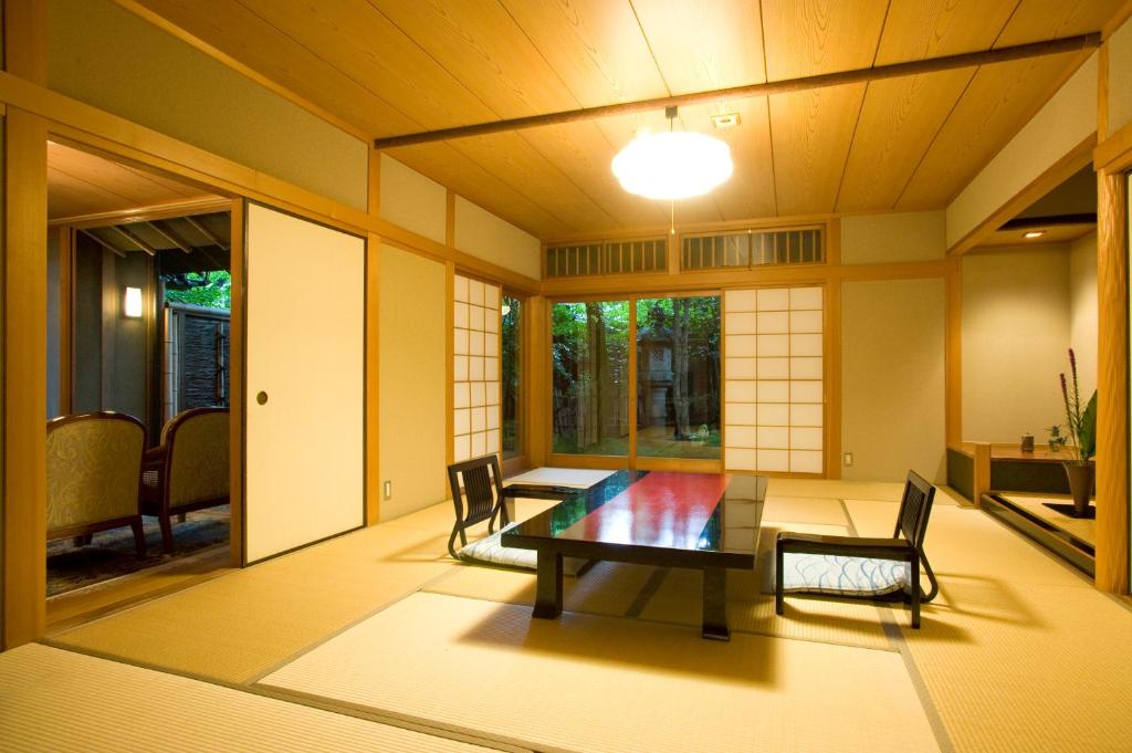 une pièce avec une table et des chaises dans une pièce dans l'établissement Ryotei Tanokura, à Yufu