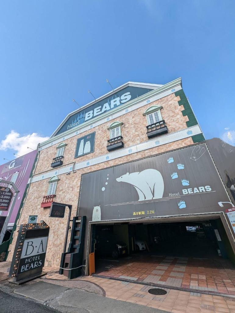 un grand bâtiment en briques avec une grande enseigne dessus dans l'établissement HOTEL ベアーズadults only, à Tenri
