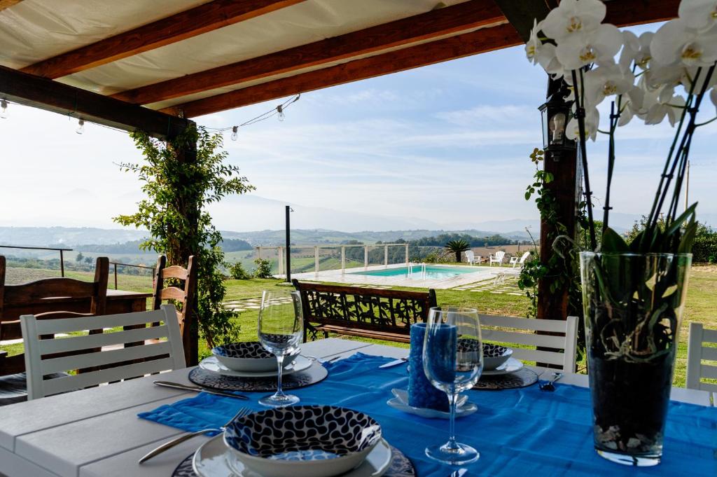 une table avec un chiffon de table bleu et des fleurs sur elle dans l'établissement Villa Fonte a Colle, à Castorano