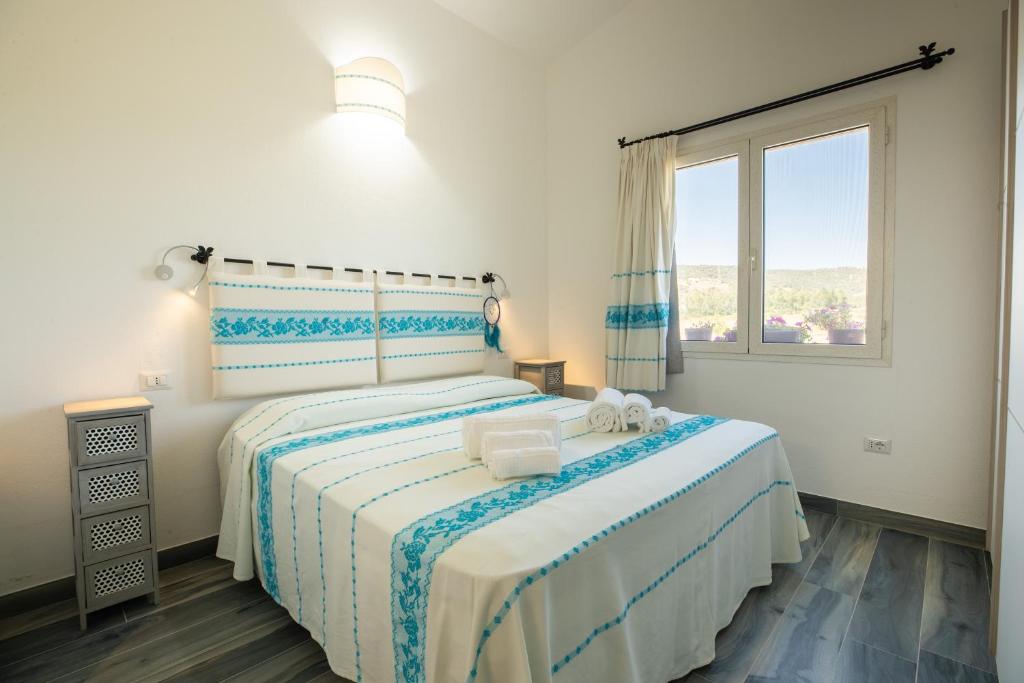 une chambre avec deux lits et une fenêtre dans l'établissement Villa S'Ena e su Juncu, à Loculi