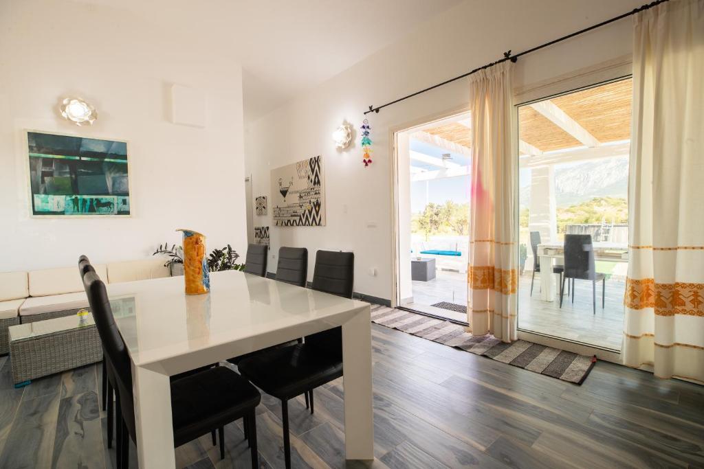 une salle à manger avec une table et des chaises blanches dans l'établissement Villa S'Ena e su Juncu, à Loculi