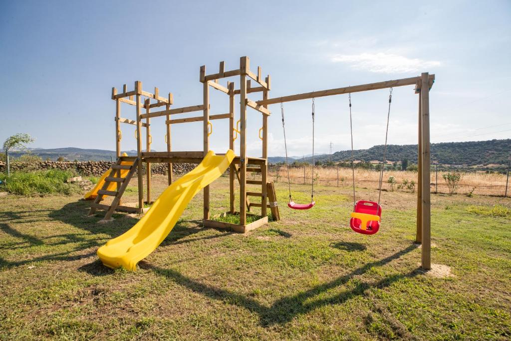 une aire de jeux vide avec toboggan et balançoires dans l'établissement Villa S'Ena e su Juncu, à Loculi