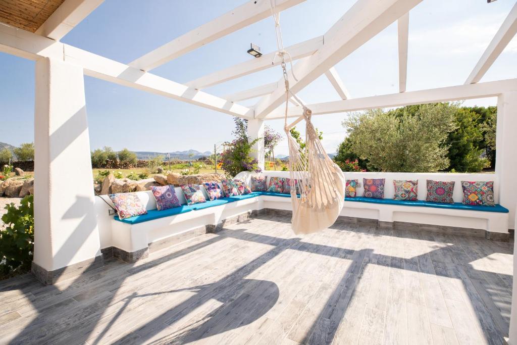 un hamac suspendu à une pergola sur la terrasse couverte d'une maison dans l'établissement Villa S'Ena e su Juncu, à Loculi