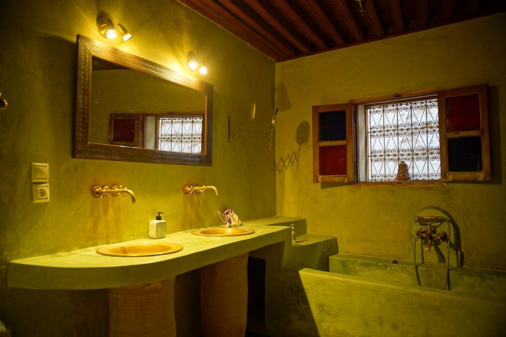 une salle de bain avec deux lavabos, une baignoire et un miroir dans l'établissement La Cheminée Bleue Fes, à Fès