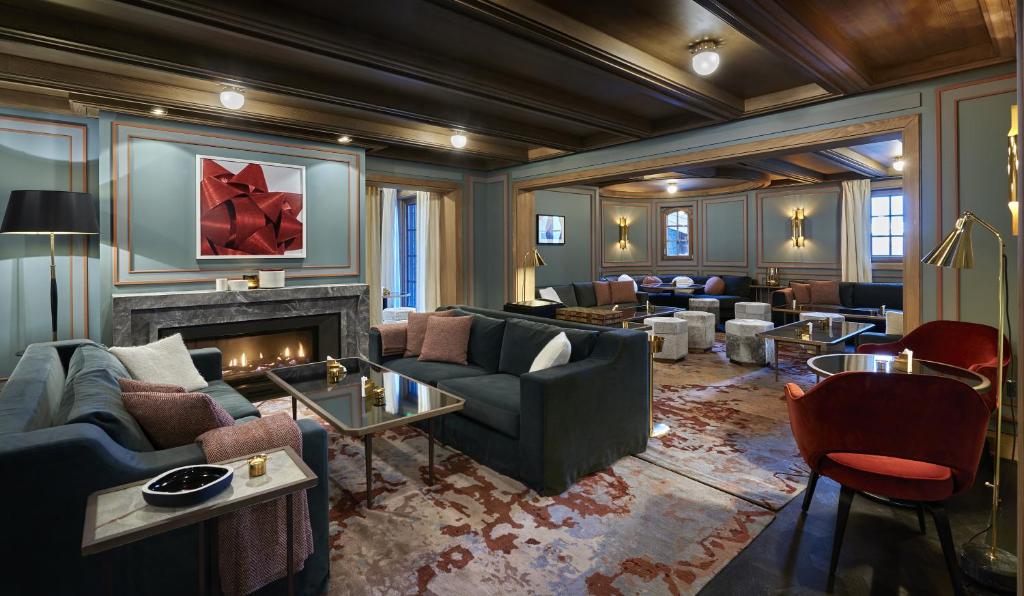 un salon avec des canapés et une cheminée dans l'établissement Apogée Courchevel, Oetker Hotels, à Courchevel