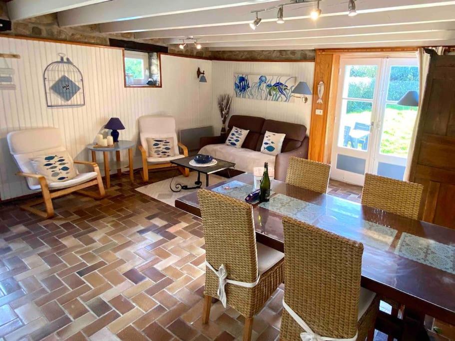 un salon avec une table, des chaises et un canapé dans l'établissement Gîte Breizh piscine ou jacuzzi, à Saint-Évarzec