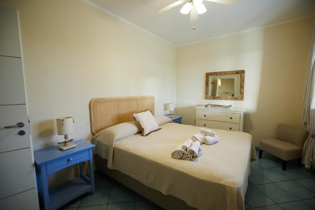 - une chambre avec deux lits, une chaise et un miroir dans l'établissement Villa Ficurinia, à Favignana 33 autres photos