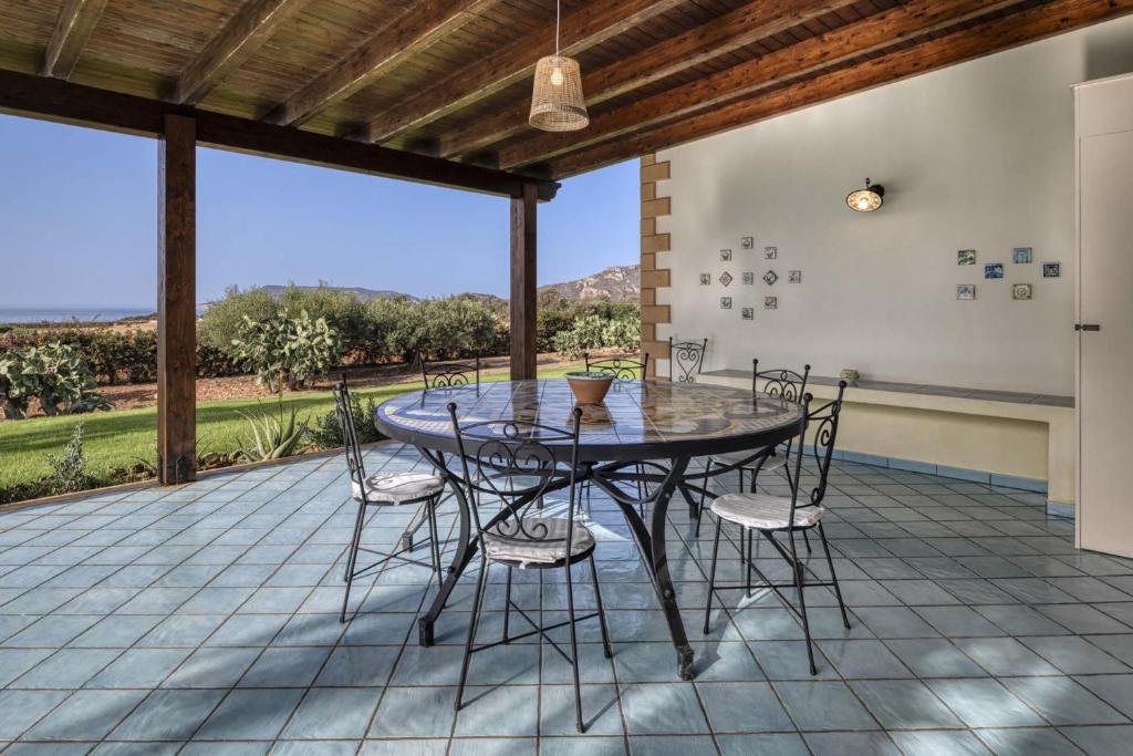 une salle à manger avec une table et des chaises sur un patio dans l'établissement Villa Ficurinia, à Favignana