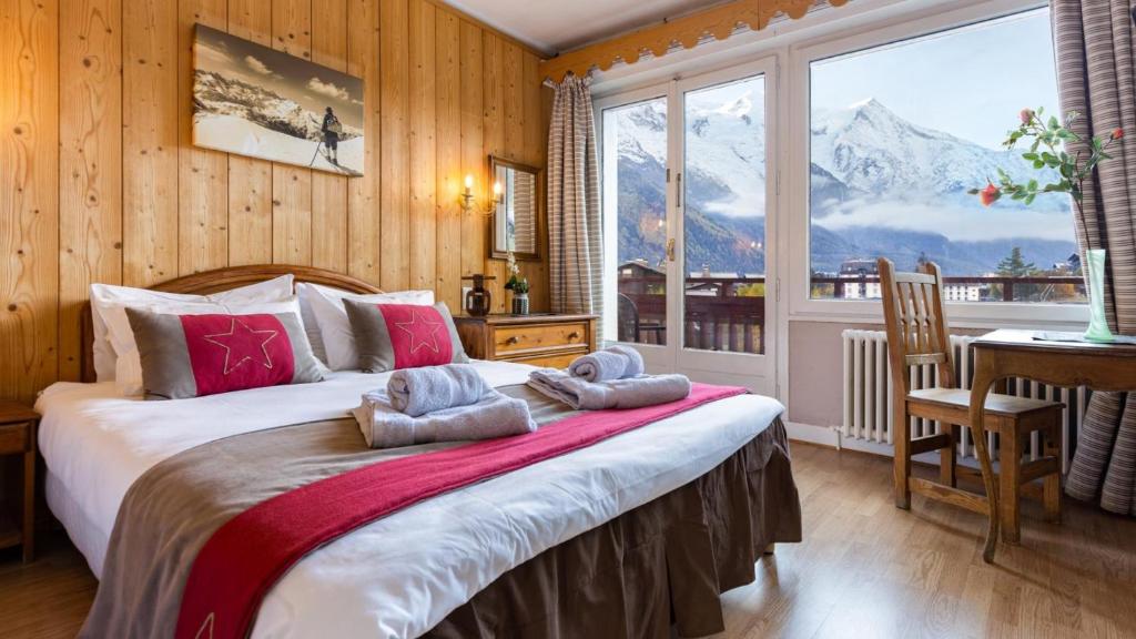 - une chambre avec un grand lit et une vue sur la montagne dans l'établissement Chalet Hôtel La Sapinière, à Chamonix-Mont-Blanc