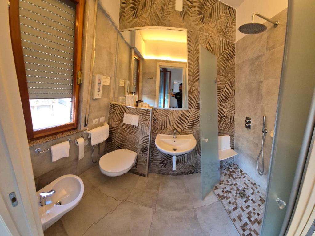 La salle de bains est pourvue de 2 lavabos et de 2 toilettes. dans l'établissement Hotel President, à San Benedetto del Tronto