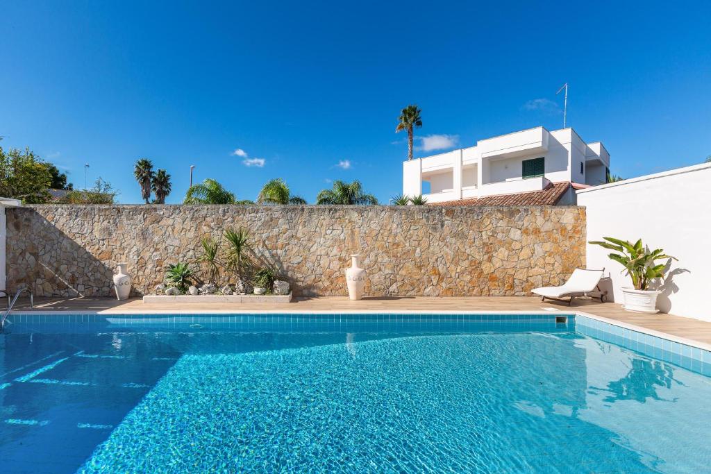 - une piscine en face d'un mur en pierre dans l'établissement Villa Goccia by BarbarHouse, à Torre dell'Orso 30 autres photos