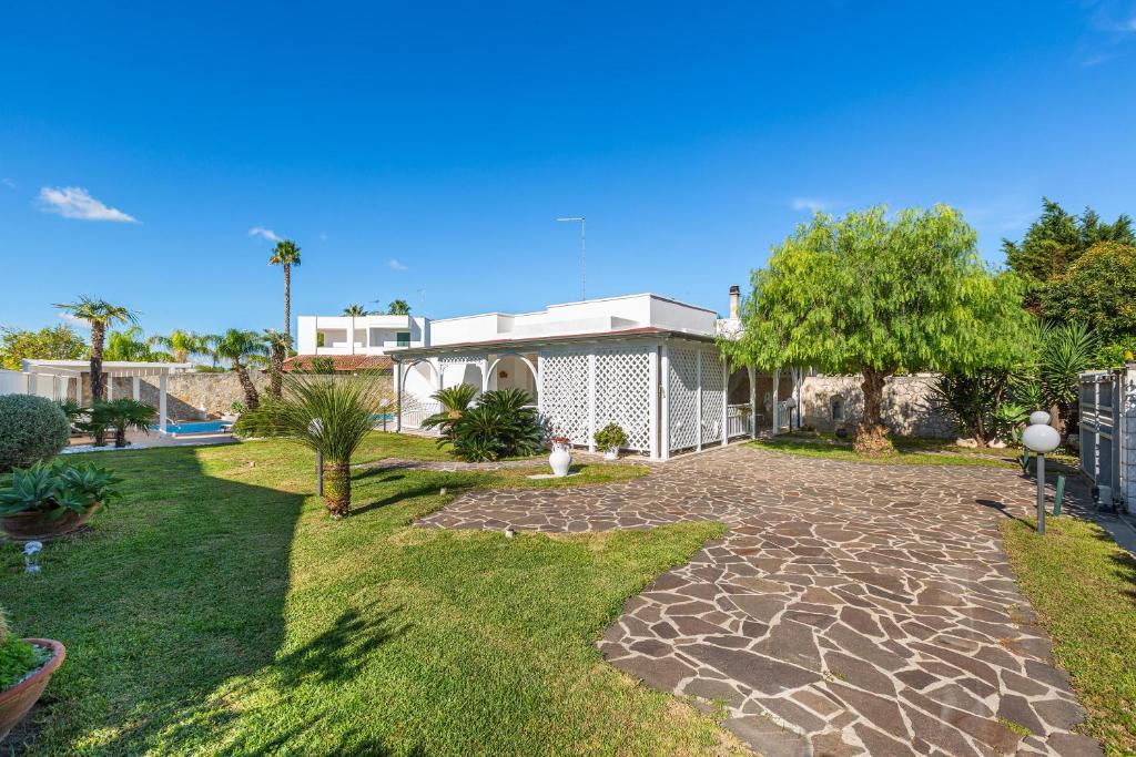 une maison avec une cour et une allée en pierre dans l'établissement Villa Goccia by BarbarHouse, à Torre dell'Orso