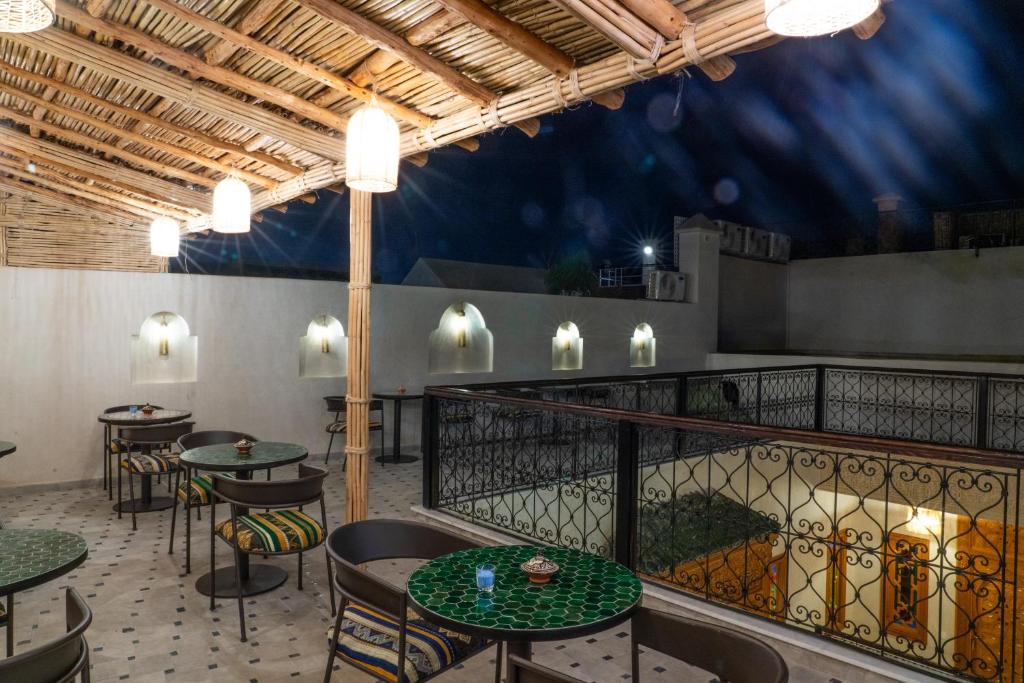 un restaurant avec des tables et des chaises sur un balcon dans l'établissement Riad Nadalinn, à Marrakech