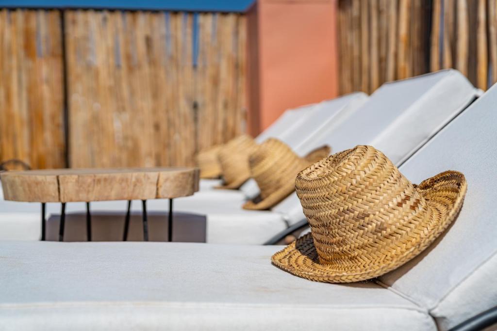 un chapeau de paille assis au-dessus d'un canapé dans l'établissement Riad Cologne & Spa, à Marrakech