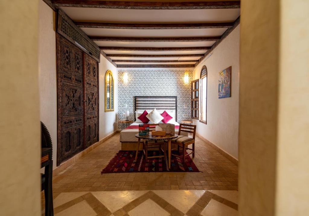 un salon avec une table et un canapé dans l'établissement Riad Cologne & Spa, à Marrakech