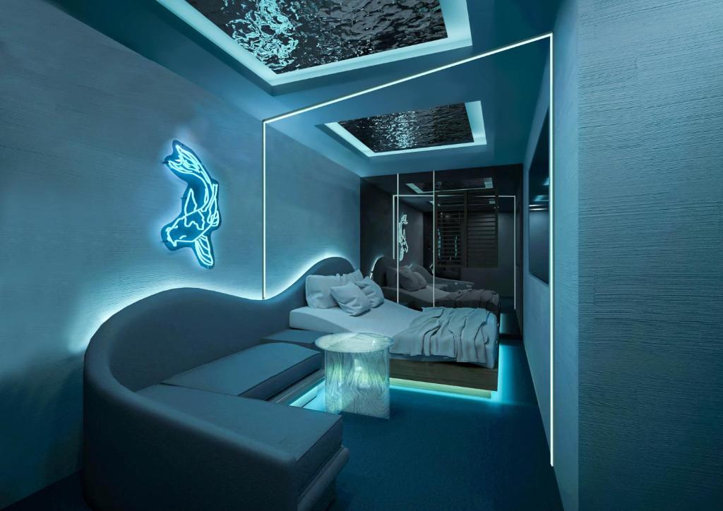 une chambre bleue avec un lit, un canapé et une table dans l'établissement Design Hotel W Zip Club, à Nagoya