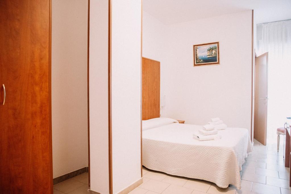 une chambre avec un lit et un miroir dans l'établissement Magnolia Hotel Vieste, à Vieste