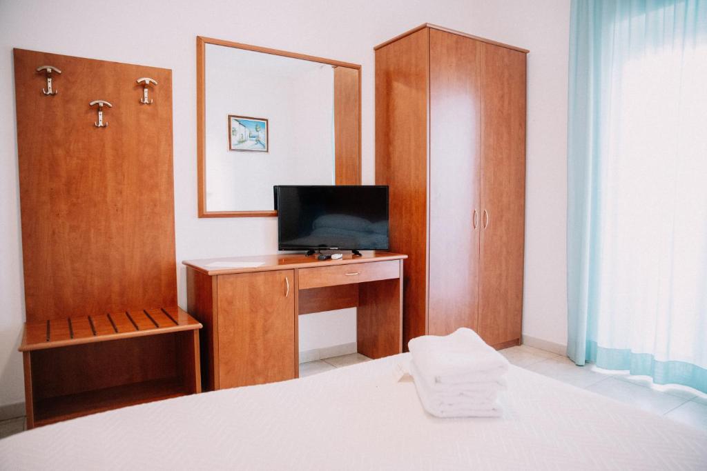une chambre avec un lit et un bureau avec une télévision dans l'établissement Magnolia Hotel Vieste, à Vieste