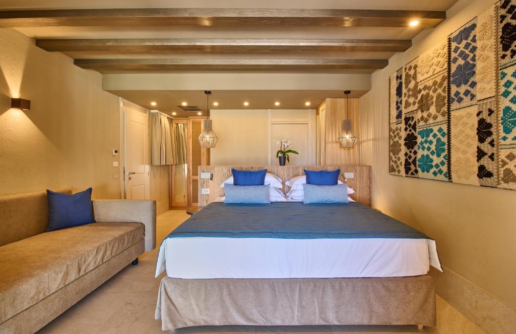 une chambre avec un grand lit et un canapé dans l'établissement Residence Le Bouganville, à Villasimius