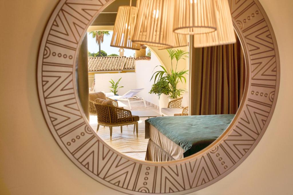 un miroir reflétant une chambre avec un lit et un salon dans l'établissement Residence Le Bouganville, à Villasimius 96 autres photos