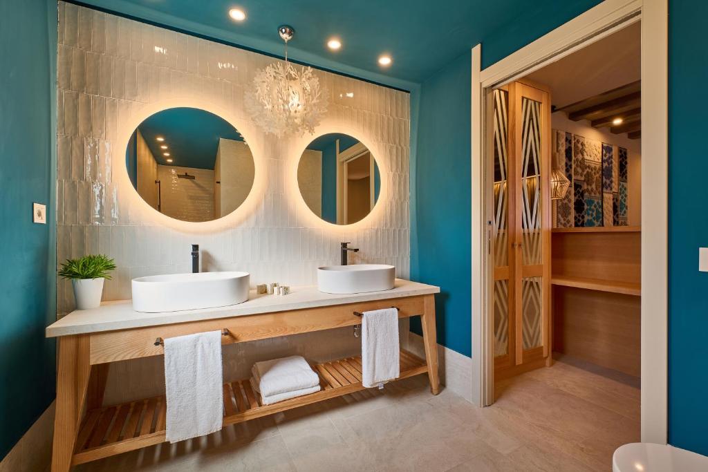 une salle de bain avec deux lavabos et deux miroirs dans l'établissement Residence Le Bouganville, à Villasimius