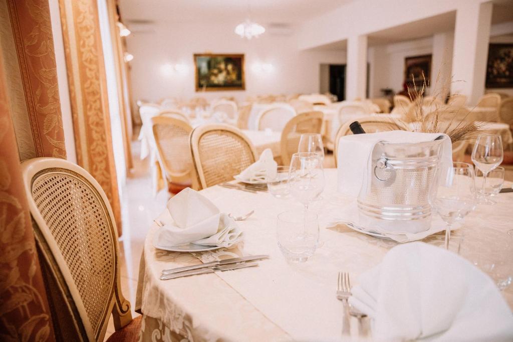 une salle à manger avec des tables et des chaises blanches dans l'établissement Magnolia Hotel Vieste, à Vieste