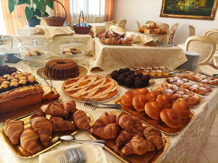 une table garnie de beaucoup de pâtisseries et de tartes dans l'établissement Magnolia Hotel Vieste, à Vieste