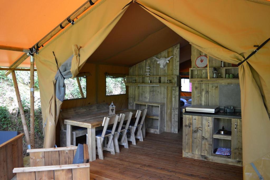 l'intérieur d'une tente avec une table et des chaises dans l'établissement Camping Moulin De Chaules, à Saint-Constant