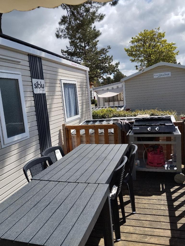 - une table de pique-nique et un grill sur une terrasse dans l'établissement mobile home photovoltaique st jean de monts, à Saint-Jean-de-Monts