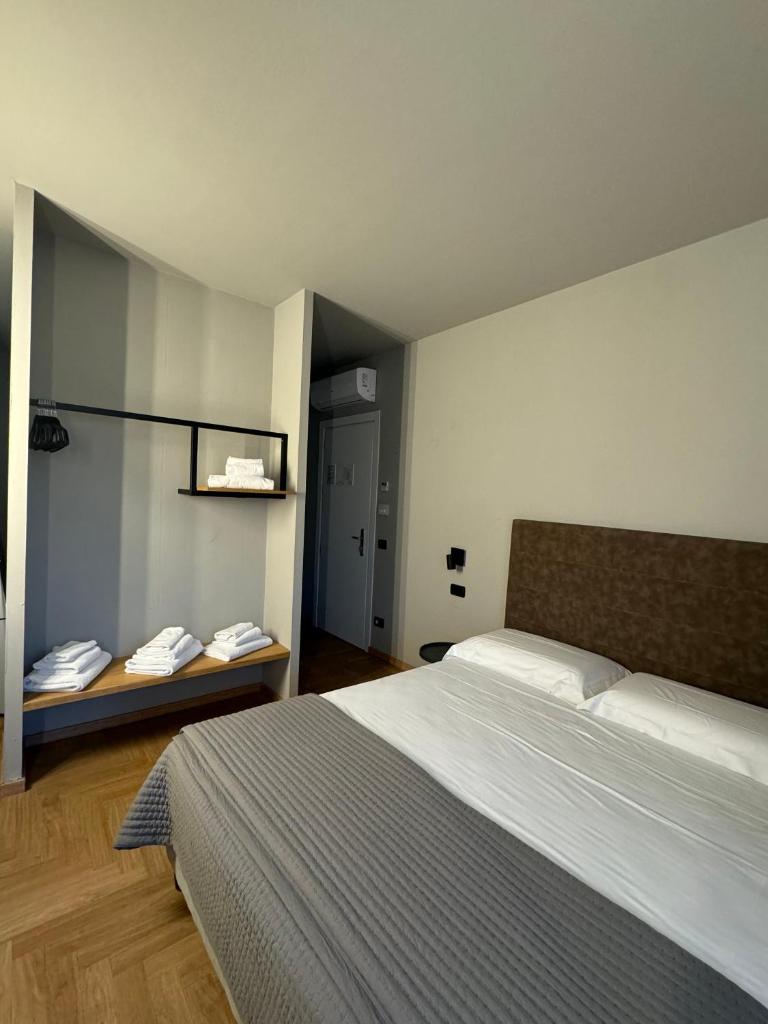 - une chambre avec un lit et une table avec des téléphones dans l'établissement RE Versiliana Junior-House, à Marina di Pietrasanta