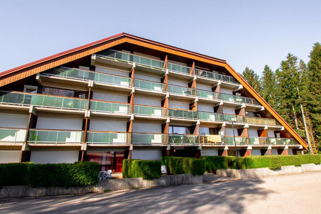 un bâtiment avec des balcons sur le côté dans l'établissement Au Doubs Refuge, à Métabief