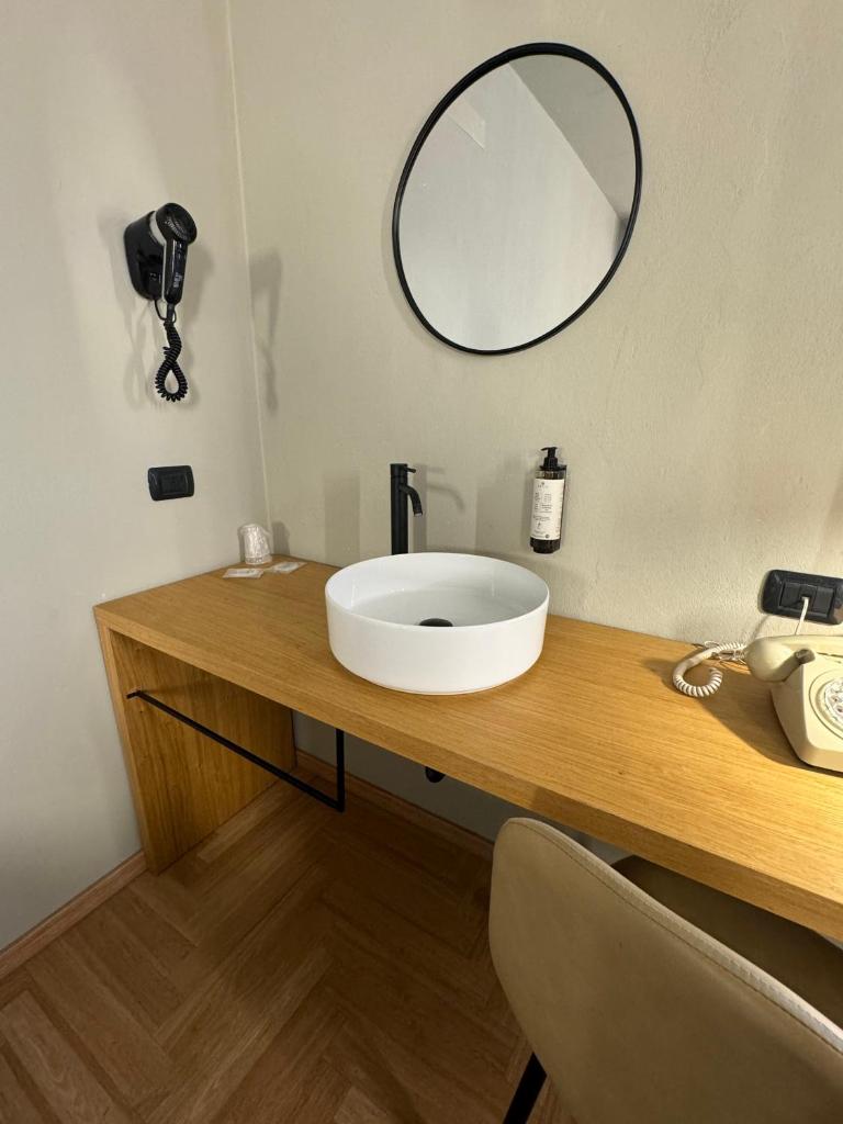 une salle de bain avec un lavabo et un miroir sur un comptoir dans l'établissement RE Versiliana Junior-House, à Marina di Pietrasanta