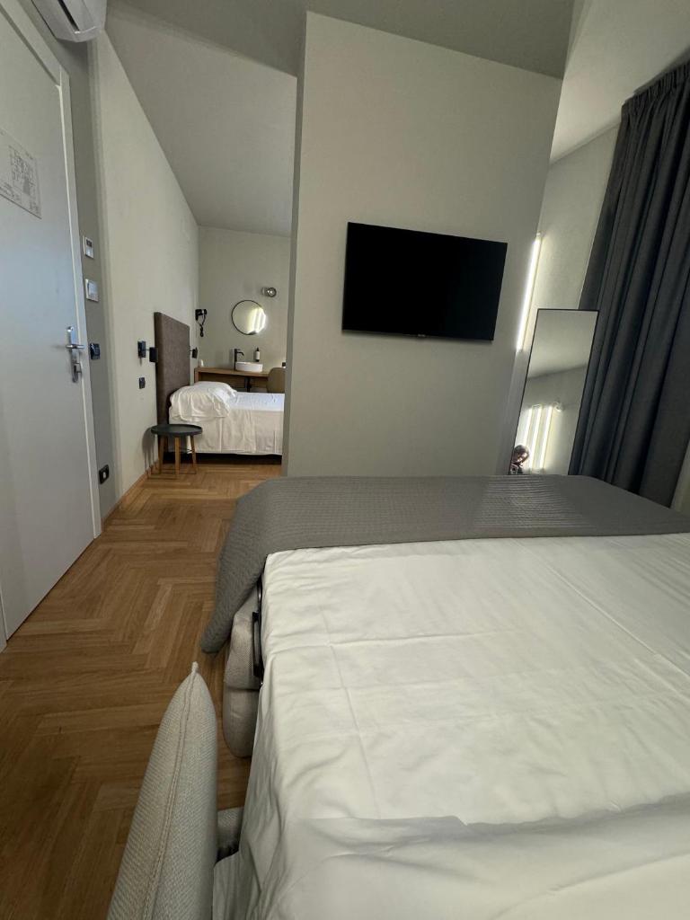 une chambre d'hôtel avec un lit et une télévision à écran plat dans l'établissement RE Versiliana Junior-House, à Marina di Pietrasanta