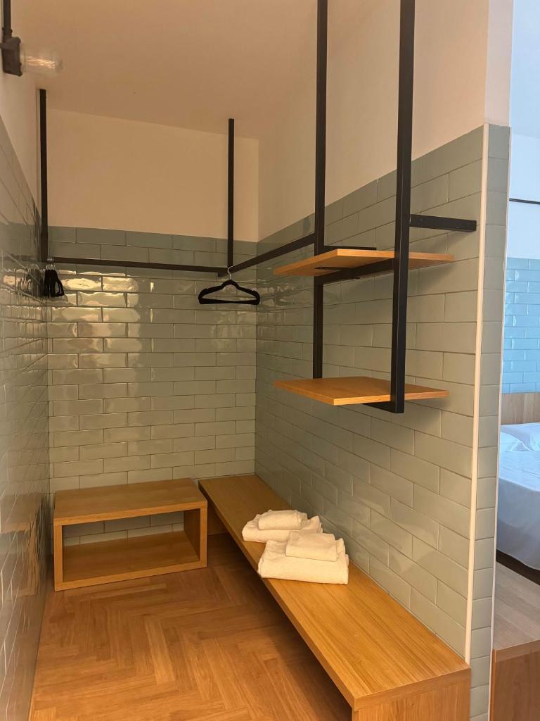 une salle de bain avec des étagères en bois sur un mur avec des serviettes dans l'établissement Re Versiliana Hotel, à Marina di Pietrasanta