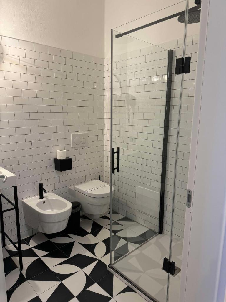 une salle de bain avec toilettes et douche en verre dans l'établissement Re Versiliana Hotel, à Marina di Pietrasanta