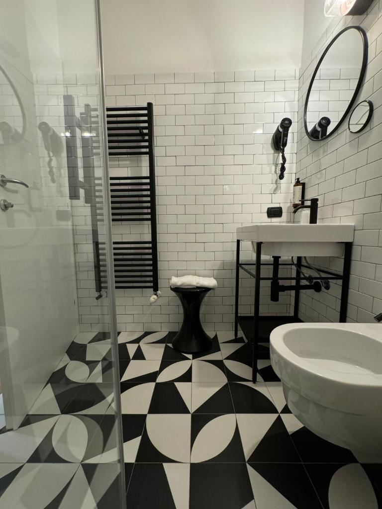 La salle de bains est pourvue d'un sol en damier noir et blanc. dans l'établissement Re Versiliana Hotel, à Marina di Pietrasanta 51 autres photos