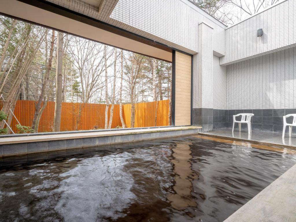 une maison avec un étang au milieu dans l'établissement Hotel Daiheigen, à Otofuke