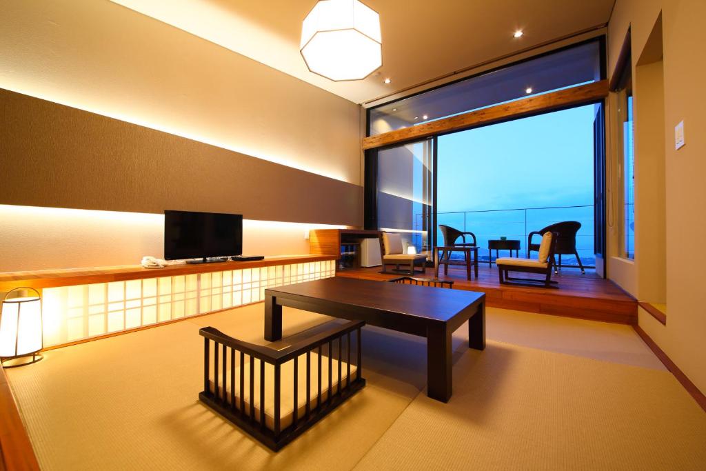 un salon avec une table et une grande fenêtre dans l'établissement SEKIYA RESORT Terrace Midoubaru, à Beppu