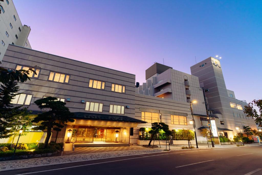 un grand bâtiment dans une rue de la ville la nuit dans l'établissement Hanabishi Hotel, à Hakodate 25 autres photos