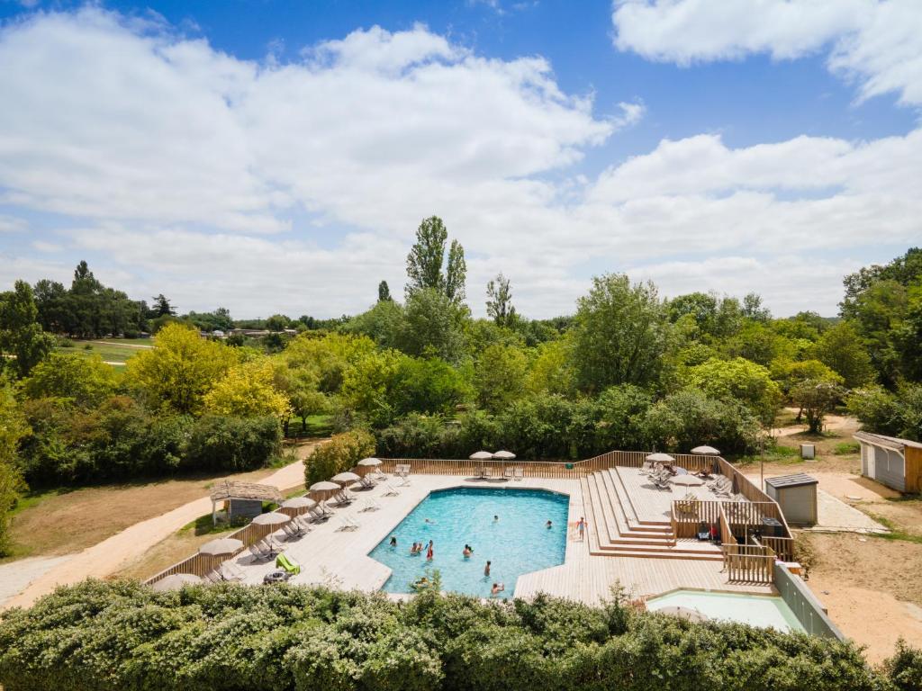 - une vue sur la piscine bordée de chaises longues et d'arbres dans l'établissement Huttopia Vallée du Lot, à Saint-Étienne-de-Villeréal 5 autres photos