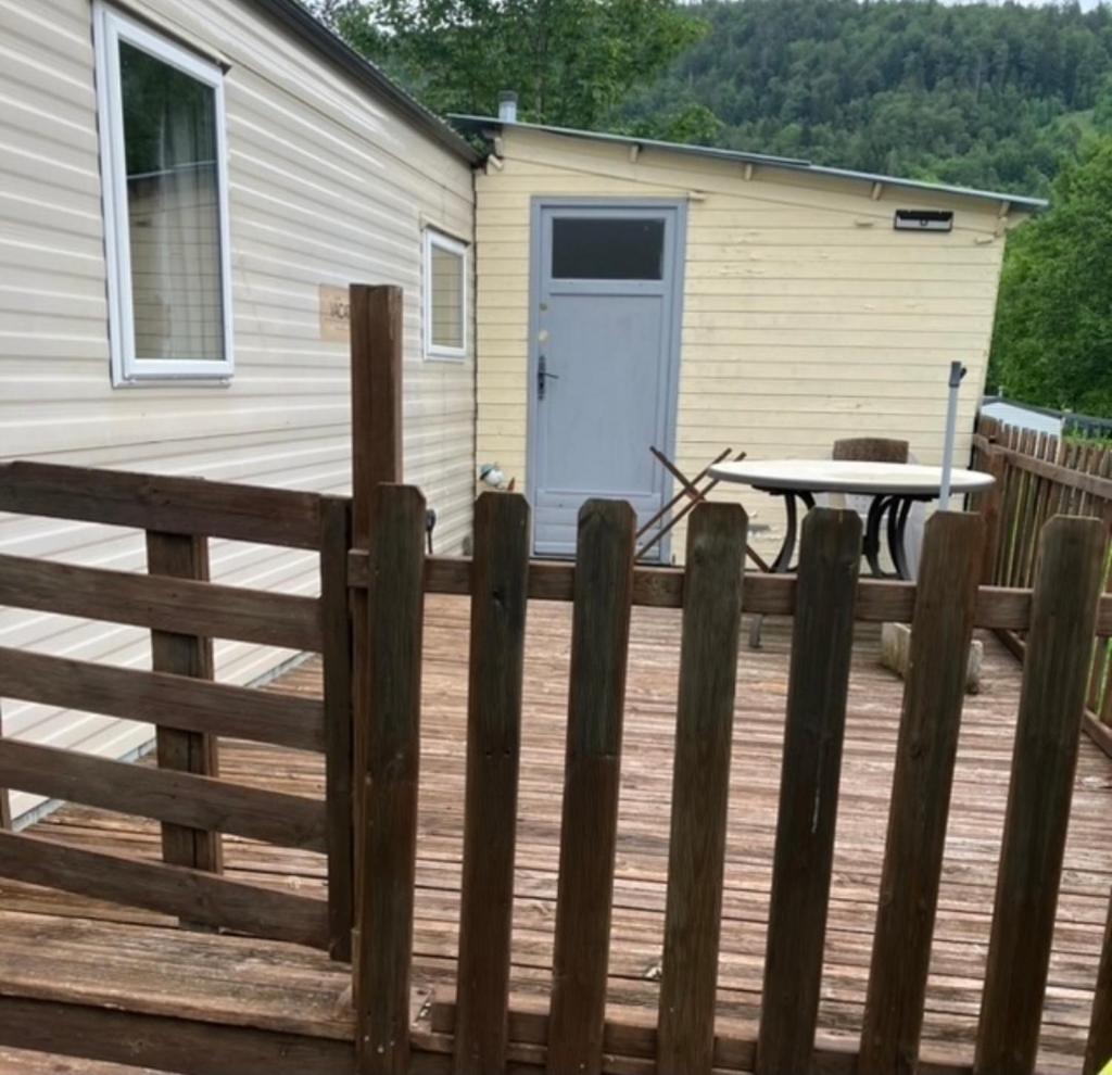 une clôture en bois sur une terrasse avec une maison dans l'établissement Ana et guigui, à Morbier
