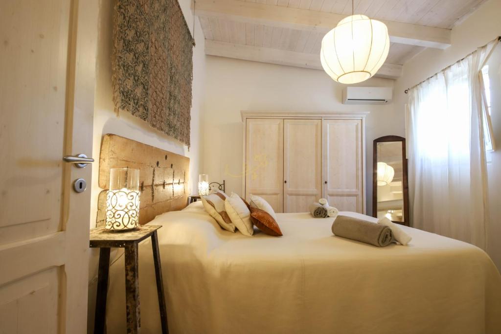 une chambre avec un grand lit blanc avec des oreillers dans l'établissement TD Trulli della Rosatella Typical Trulli with Pool, à Castellana Grotte