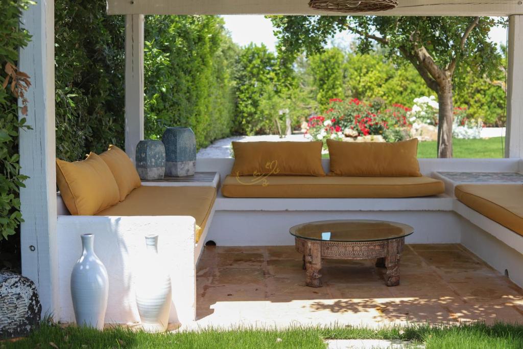 d'une terrasse avec un canapé et une table basse. dans l'établissement TD Trulli della Rosatella Typical Trulli with Pool, à Castellana Grotte 31 autres photos