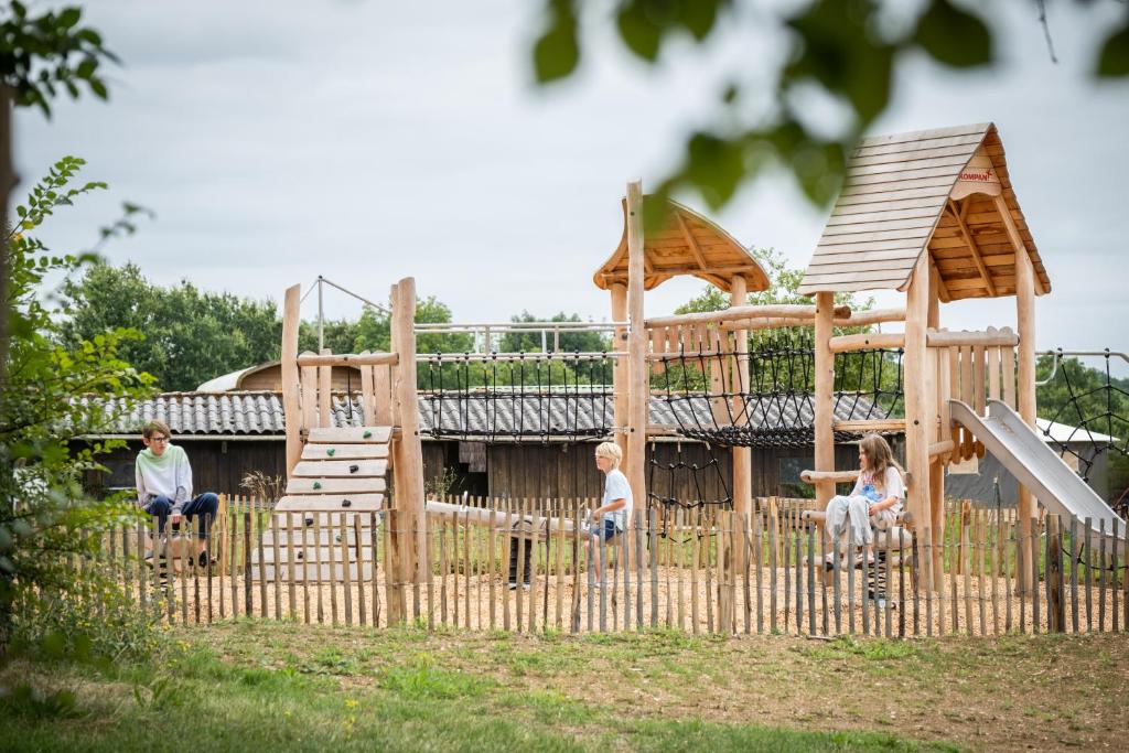 un groupe de personnes assis devant une aire de jeux dans l'établissement Huttopia Vallée du Lot, à Saint-Étienne-de-Villeréal