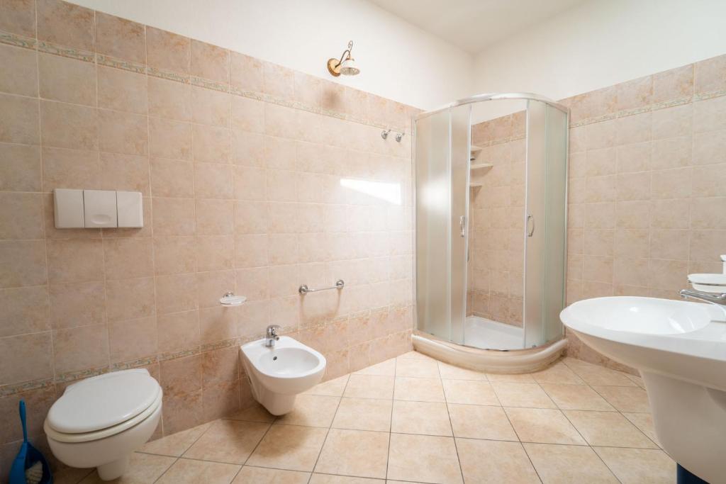 une salle de bain avec toilettes, lavabo et douche dans l'établissement Residence Corte Dei Venti, à Budoni
