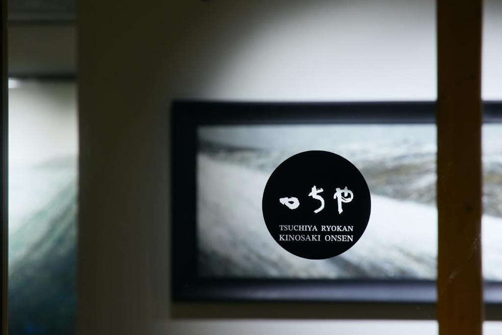un panneau devant une photo dans une fenêtre dans l'établissement TSUCHIYA Kinosaki onsen, à Toyooka