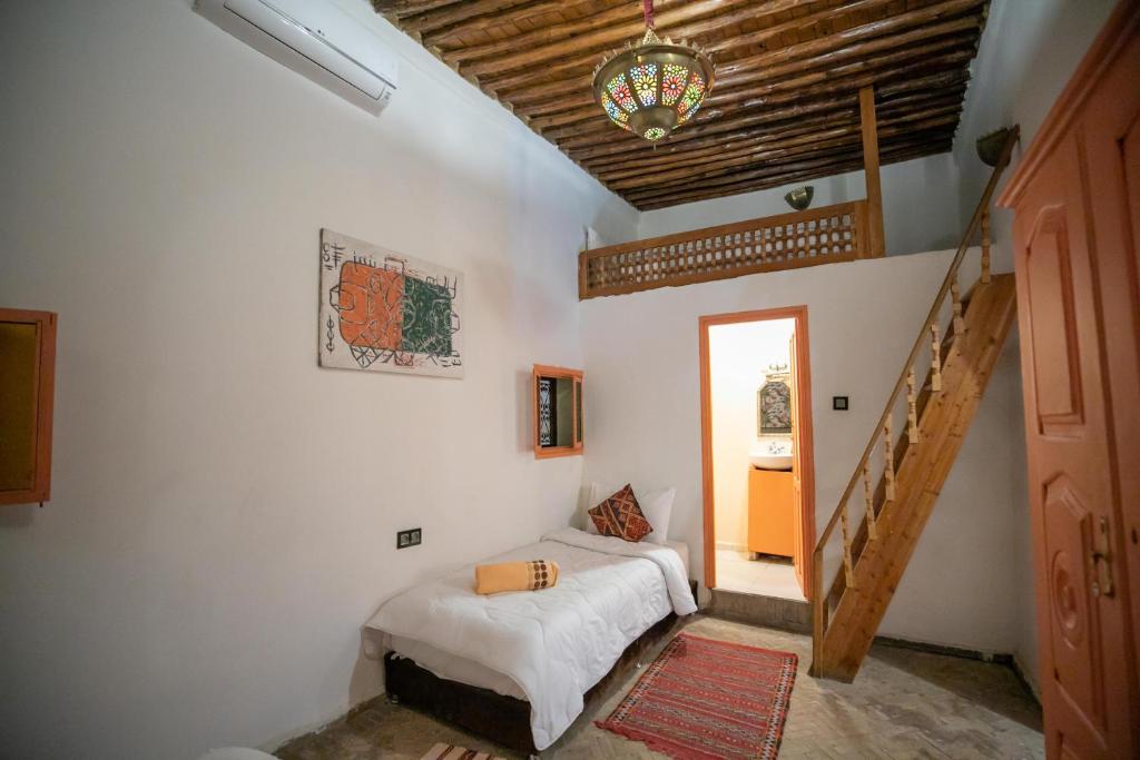 une chambre avec un lit dans une pièce avec un escalier dans l'établissement Riad dar Merzouga, à Fès