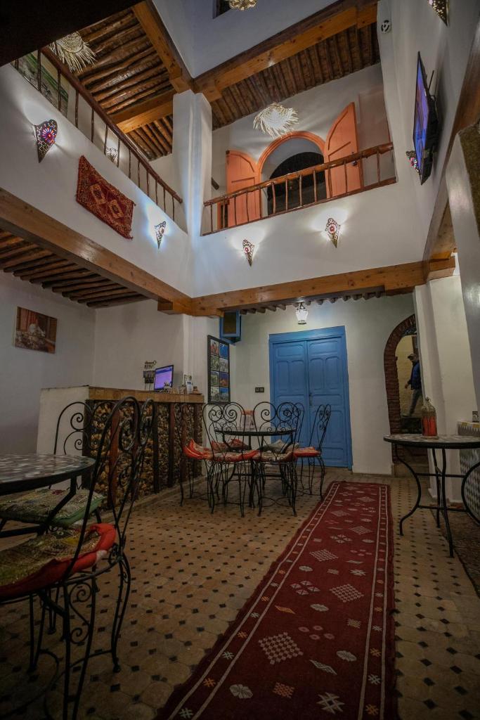 un restaurant avec des tables et des chaises et une porte bleue dans l'établissement Riad dar Merzouga, à Fès